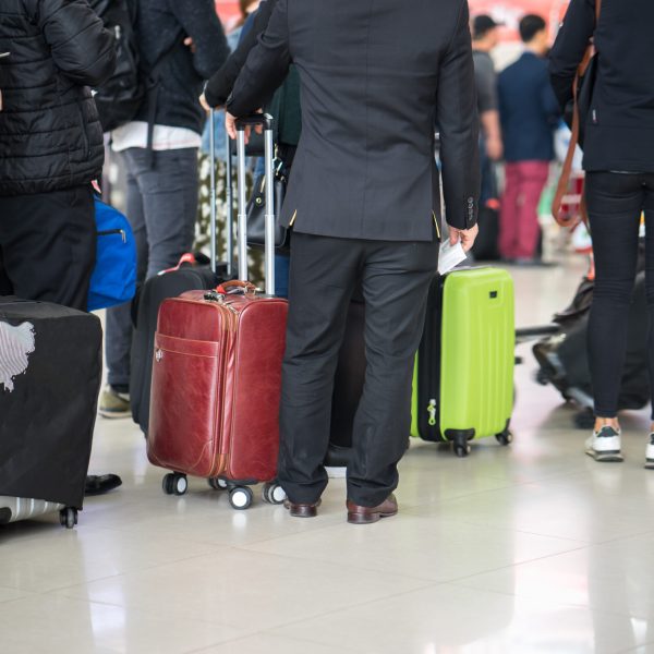 Queue of Asian people waiting at boarding gate at airport. Closeup.